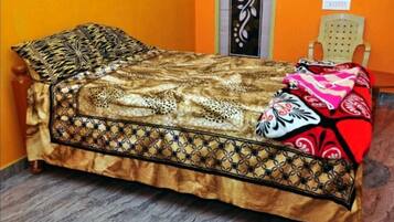 Una cama con una colcha estampada y un cojín decorativo.