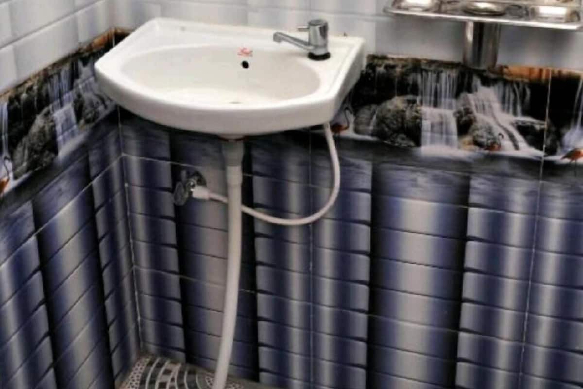 A bathroom with a white sink, a mirror, and a tiled wall.