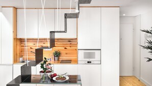 Una cocina moderna con una pared de acento de madera, un comedor con taburetes y una escalera que lleva a un nivel superior.