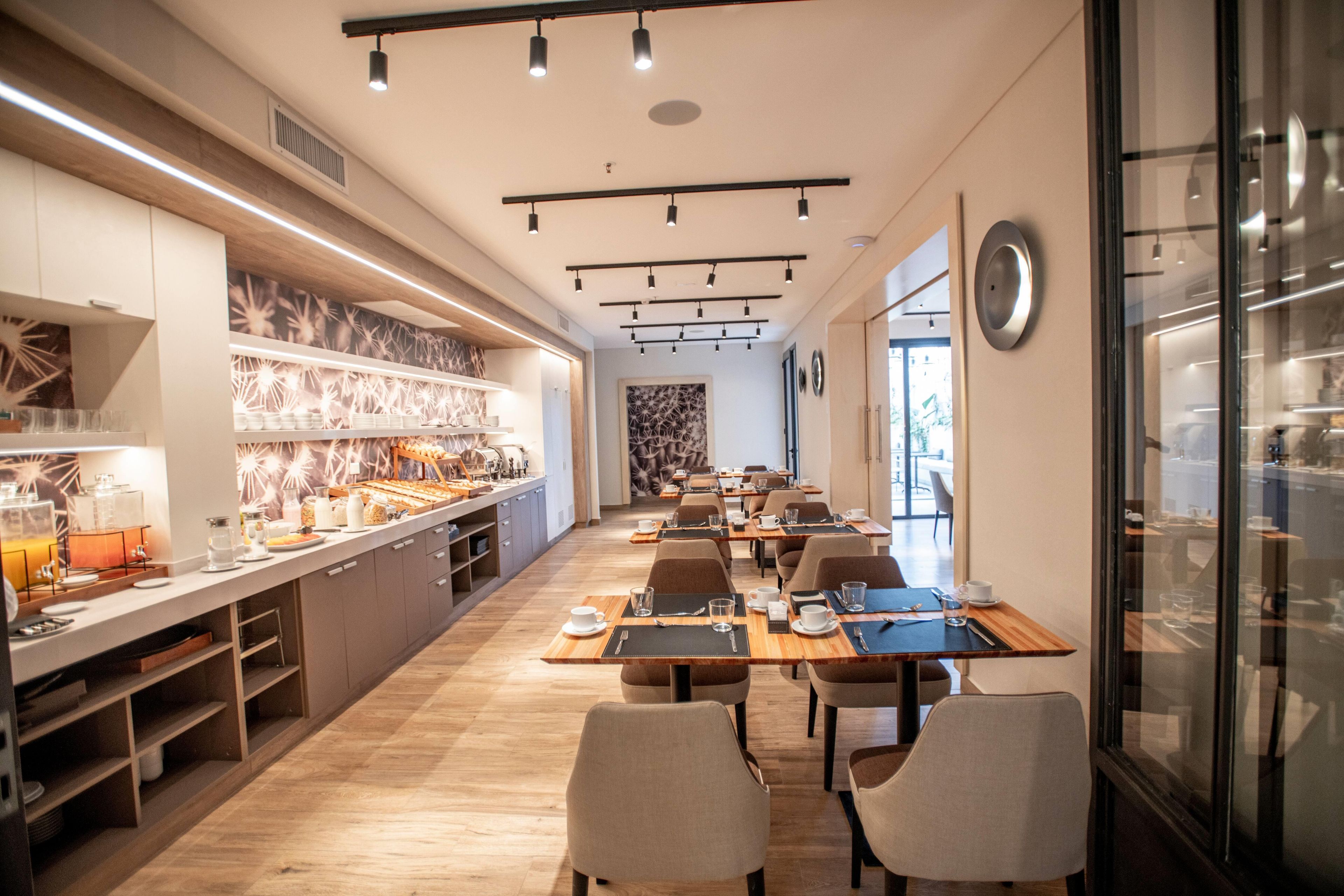 Un espace repas moderne doté d’un long comptoir, de plusieurs tables et de chaises.