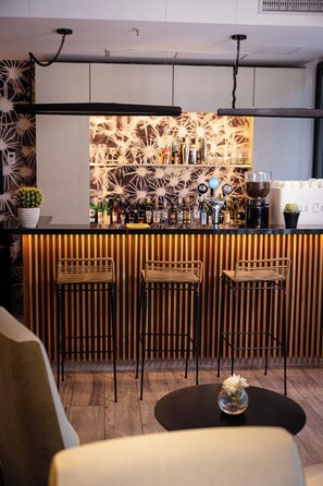 A bar area with a wooden slat wall, bar stools, and a variety of bottles and glasses.