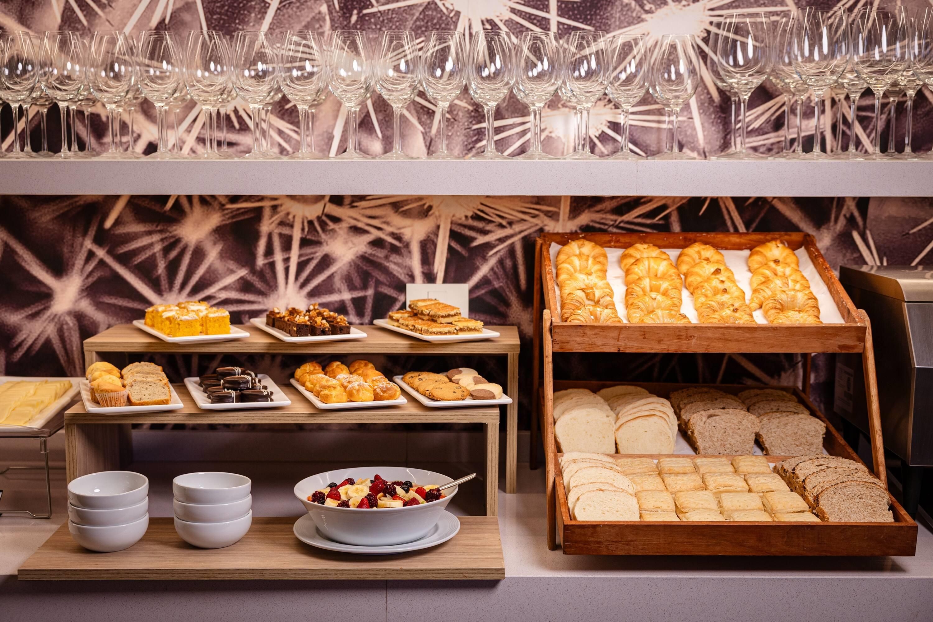 Un buffet proposant une variété de plats et une sélection de verres à vin.