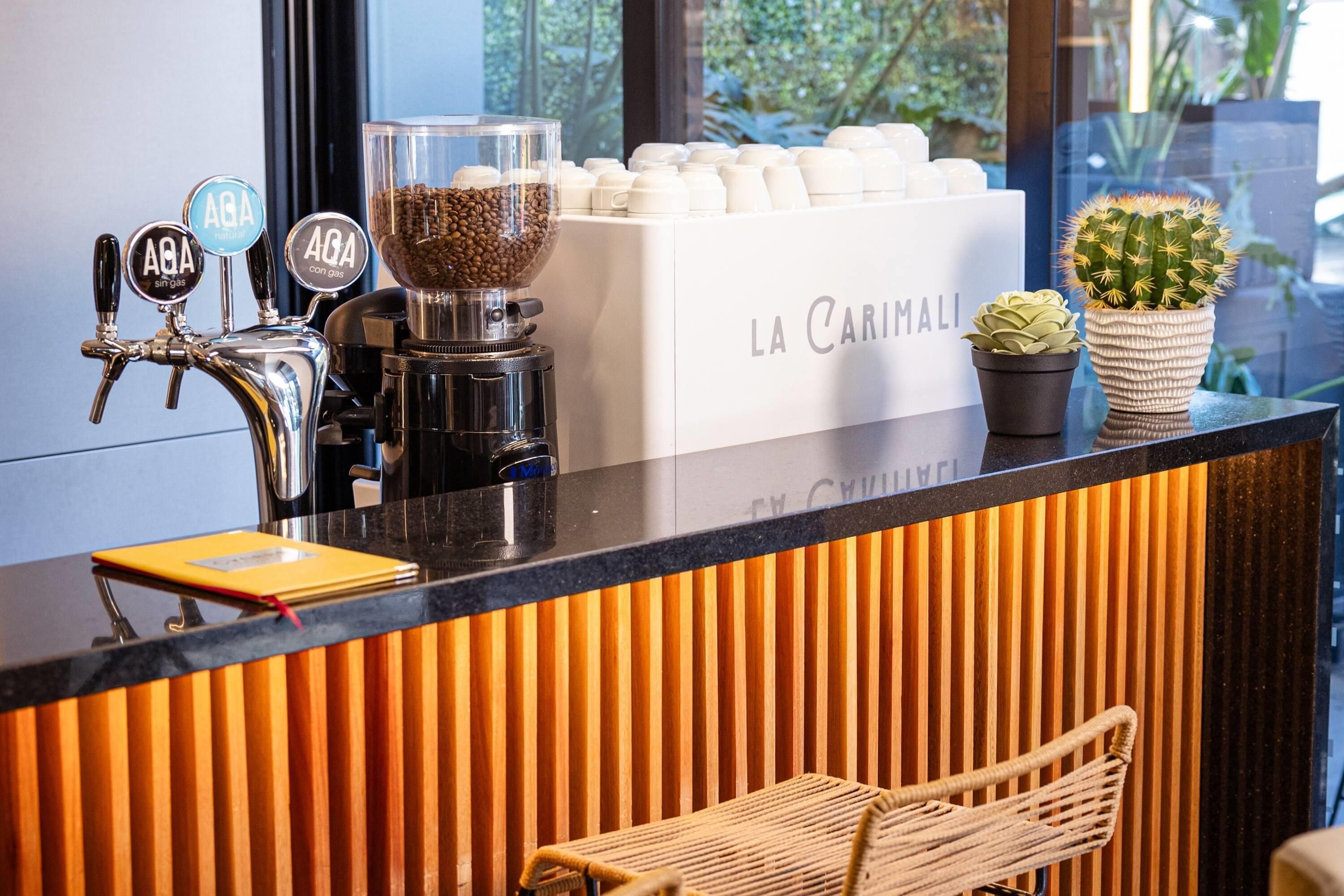 Ein Café mit einer Kaffeemühle, einer Kaffeemaschine und einer Auswahl an Kaffeetassen.