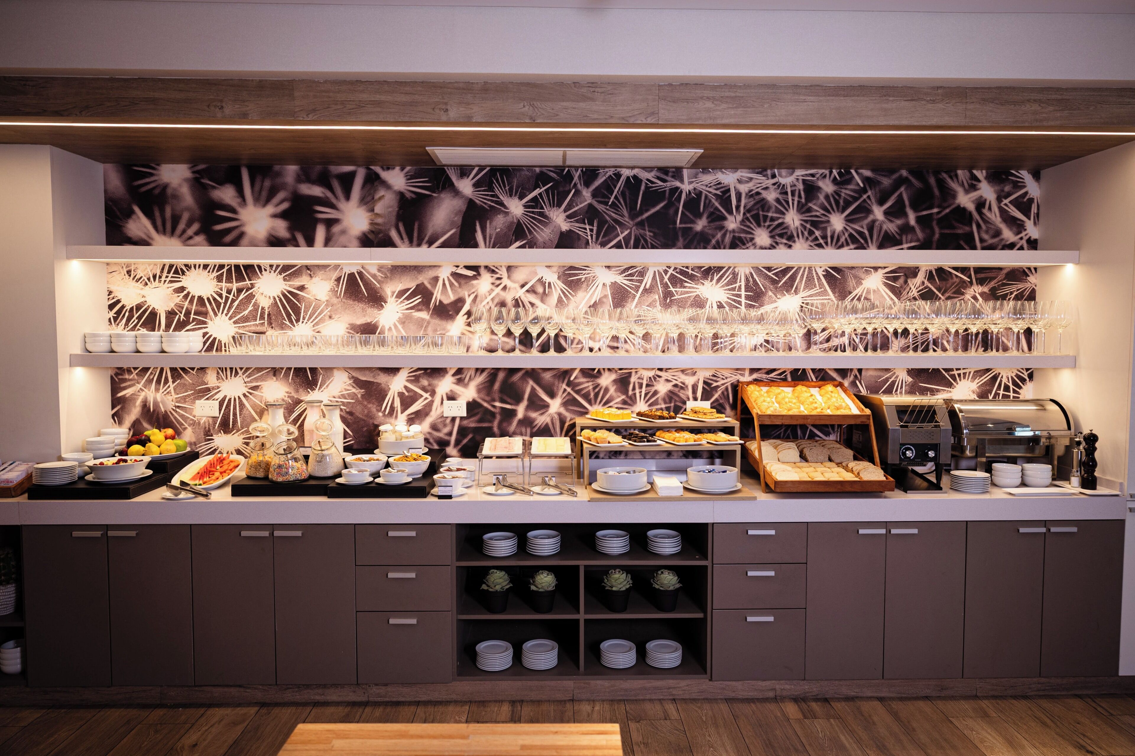 Ein reichhaltiges Buffet mit verschiedenen Speisen, einer Kaffeemaschine und einer dekorativen Wand.