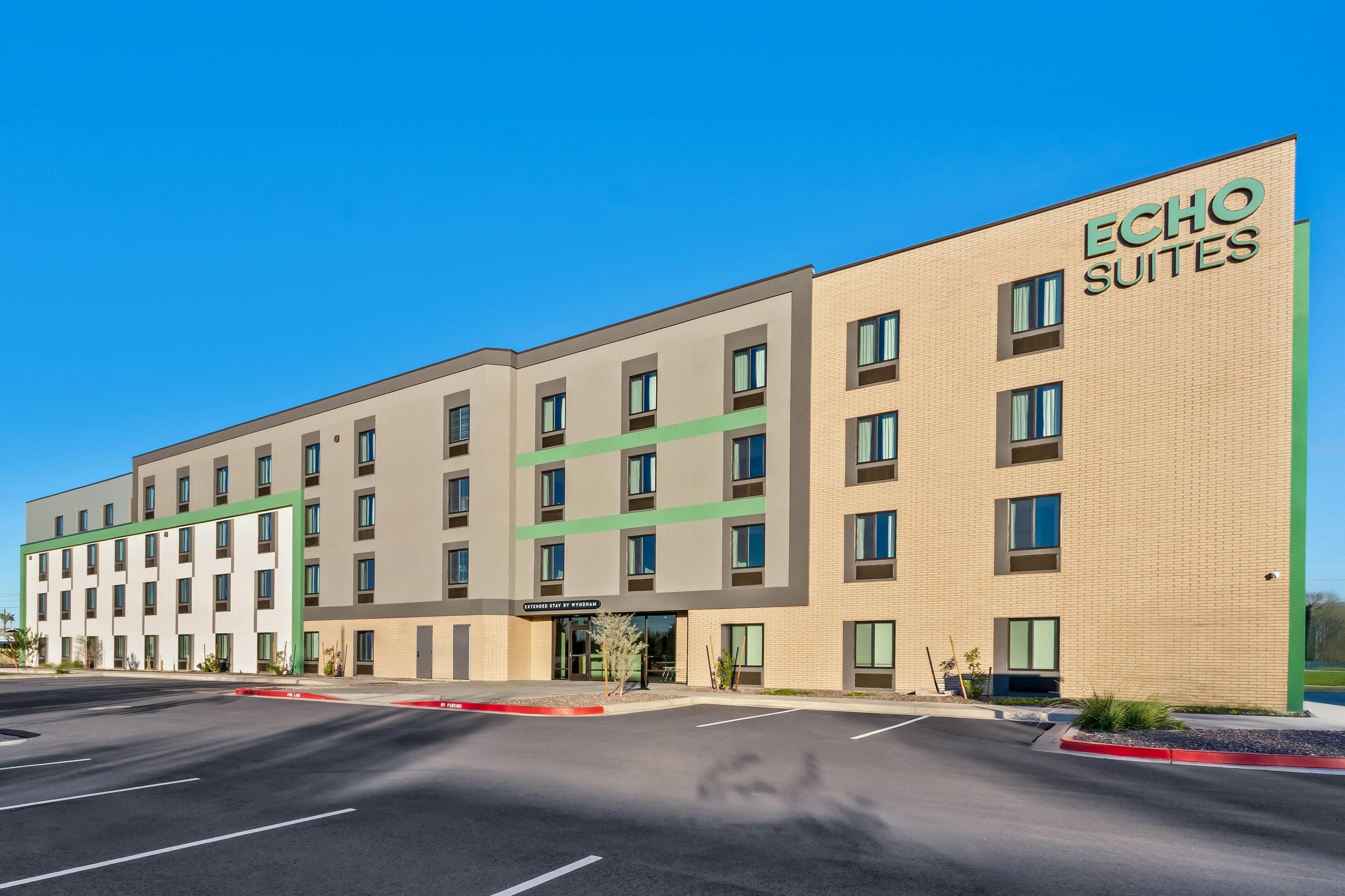 Un hotel moderno con fachada plana, múltiples ventanas y señalización destacada que dice 'Echo Suites'.