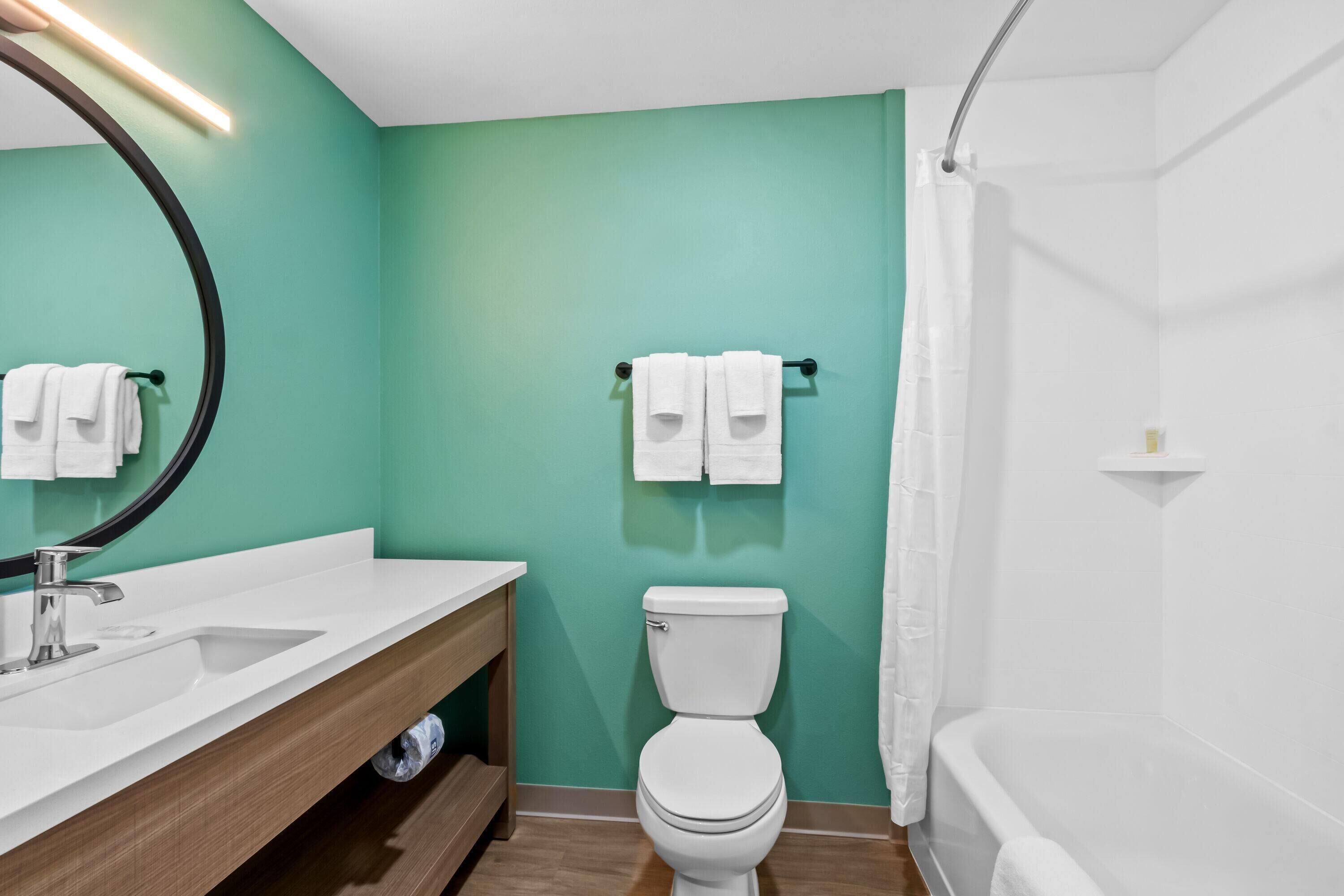 Une salle de bain avec un lavabo blanc, des toilettes et une douche.