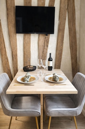 Una mesa de comedor con dos platos, una botella de vino y copas.