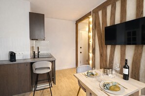 A modern kitchen with a built-in oven, a coffee maker, and a bar stool. - 1614 Sevres (Paris)