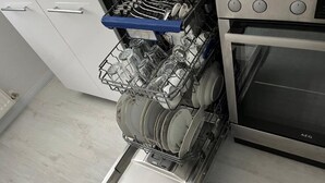 A dishwasher with a glassware basket full of glasses and a control panel with buttons. - Apartment 'Meisteroffice Im Sackgässle' with Shared Garden and Wi-Fi (Dornstadt)