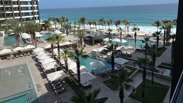 A resort with multiple swimming pools, palm trees, and a view of the ocean. - Cabo San Lucas! - It's your choice - Jr. Suite, 1 or 2-bedroom resort stay! (Cabo San Lucas)