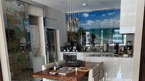 A modern kitchen with a large island, stainless steel appliances, and a view of the ocean through a window. - Cabo San Lucas! - It's your choice - Jr. Suite, 1 or 2-bedroom resort stay! (Cabo San Lucas)