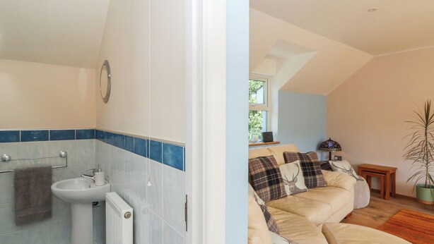 A bathroom with a sink, mirror, and towel rack. - 1 Bryn Beudy (Narberth)