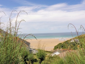 A coastal landscape with a beach, houses, and vegetation. - 8 Karn Havos (Wadebridge)