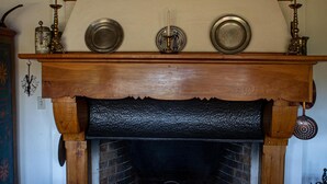 A traditional fireplace with a wooden mantel, a brick surround, and decorative plates above.