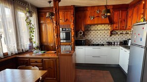 A kitchen with wooden cabinets, a white countertop, and a tiled floor. - Charming 2-bedroom apartment with AC, WiFi in awesome Venice (Venice)