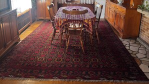 A dining area with a wooden table and chairs, a patterned rug, and a chandelier. - Charming 2-bedroom apartment with AC, WiFi in awesome Venice (Venice)
