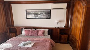 A bedroom with a large bed, a framed picture on the wall, and wooden paneling. - Charming 2-bedroom apartment with AC, WiFi in awesome Venice (Venice)