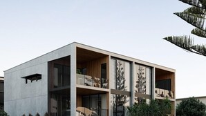 Een modern herenhuis met twee verdiepingen, met een minimalistisch ontwerp, grote ramen en een plat dak.