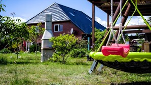 Un quartier résidentiel avec une maison, une balançoire et une pelouse.