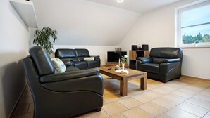 Un salon moderne avec un canapé, une table basse et un téléviseur.