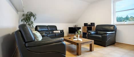 Een moderne woonkamer met een bank, een salontafel en een televisie.