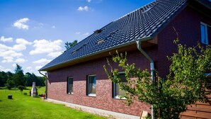 Une maison avec un toit en pente, une façade en briques et une pelouse bien entretenue.