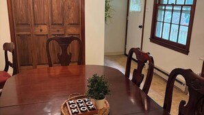 Une salle à manger avec une table en bois, des chaises, un ventilateur de plafond et une fenêtre donnant sur un beau paysage.