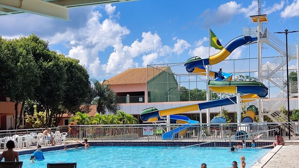 Una piscina con toboganes y un área cercada.