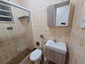 Une petite salle de bain avec des toilettes, un lavabo et un miroir.