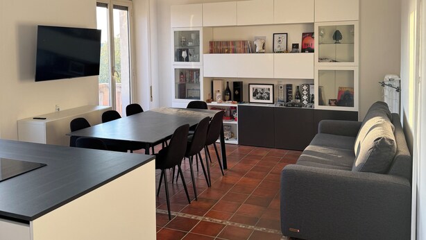 A modern living space with a dining area, kitchen, and seating area. - The Monteverde Penthouse (Roma)