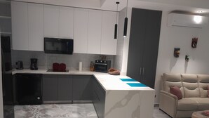 A modern kitchen with white cabinets, a built-in microwave, and a coffee maker. - Charming 2-bedroom house in enjoyable Playa del Coco with WiFi, AC (Playa del Coco)