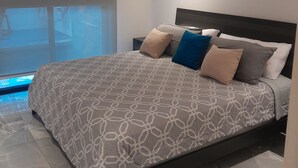 A modern bedroom with a large bed, a built-in window, and a small pool. - Charming 2-bedroom house in enjoyable Playa del Coco with WiFi, AC (Playa del Coco)