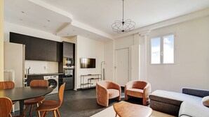 Een moderne woonkamer met een eethoek, een bank en een televisie.