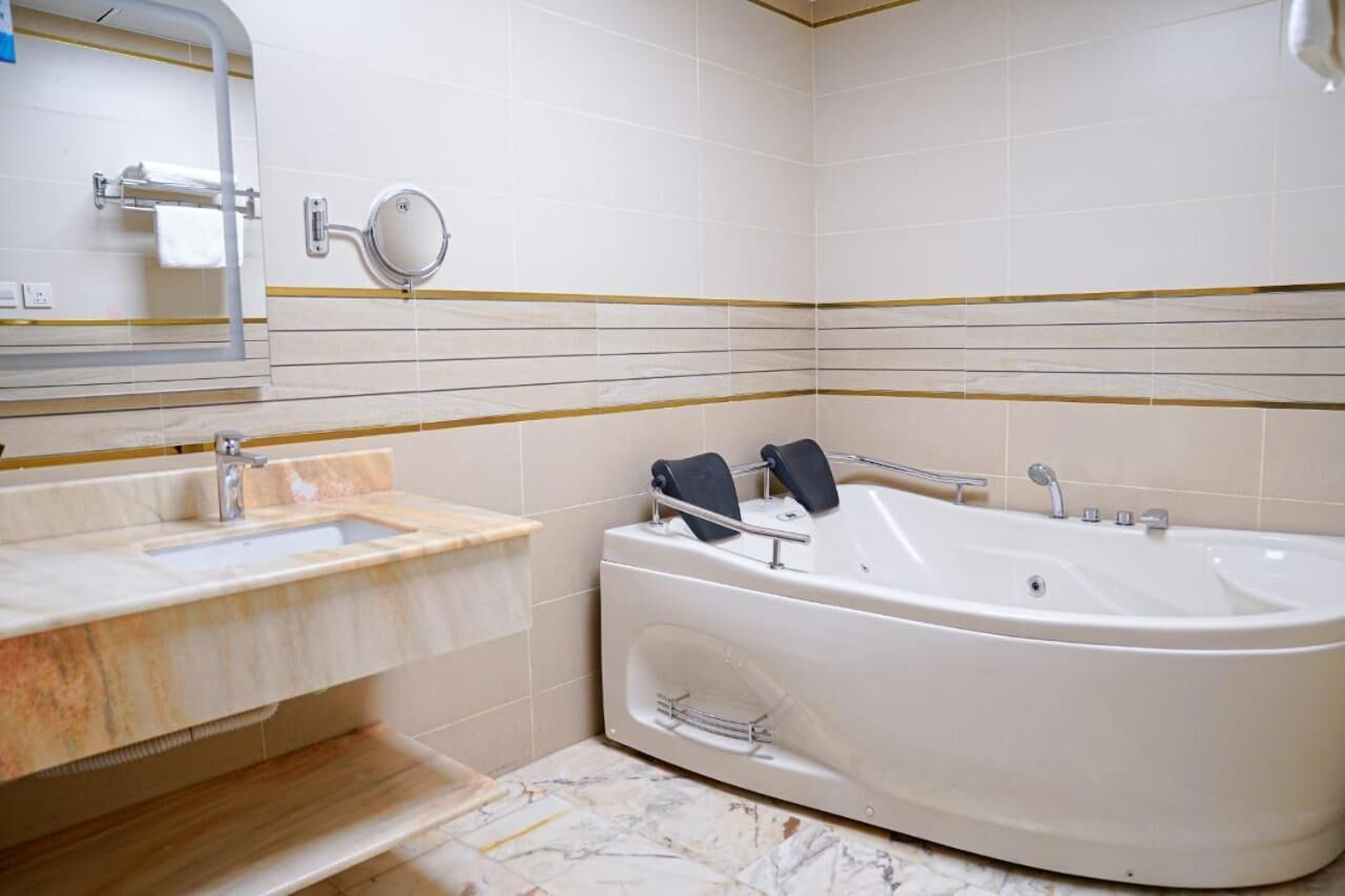 A bathroom with a bathtub, a sink, and a mirror.