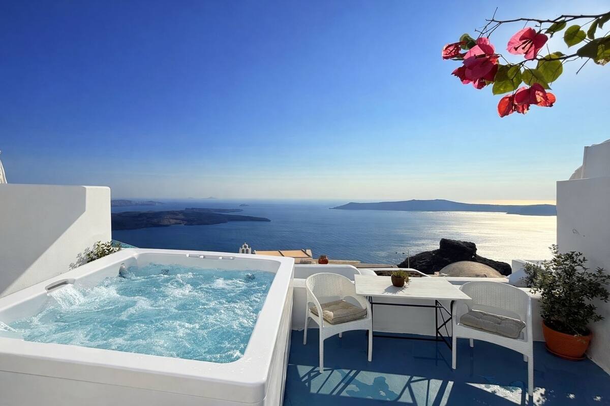 Una terrazza sul tetto con idromassaggio, mobili bianchi e vista sul mare.