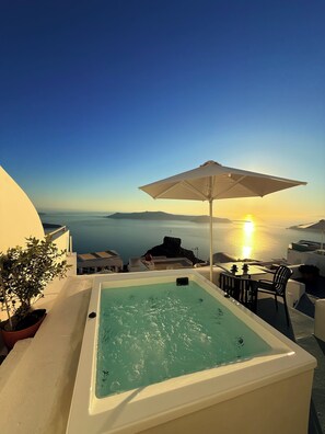 Una piscina en la azotea con vistas al mar y al atardecer.