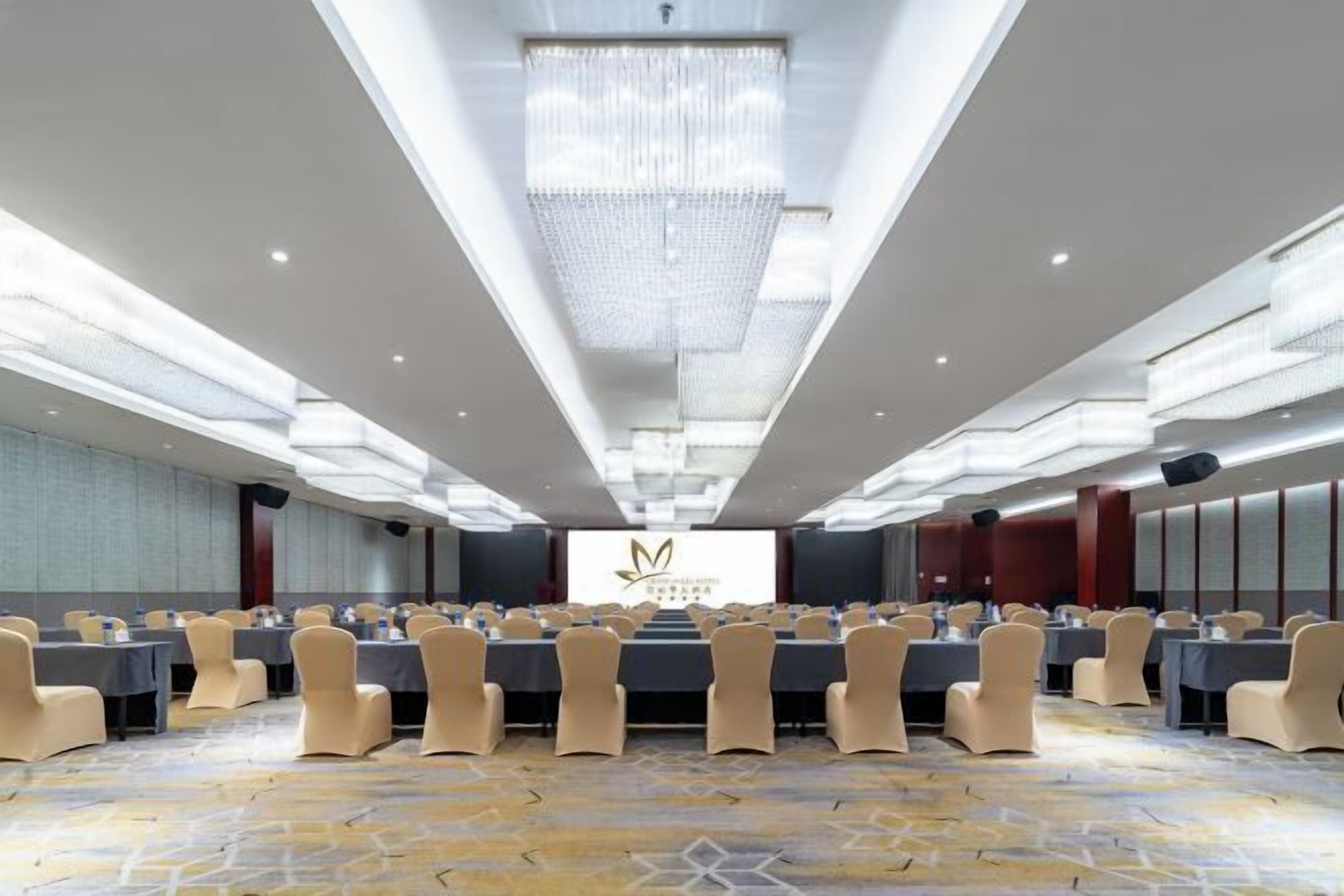 A conference room with a long table, chairs, and a chandelier.