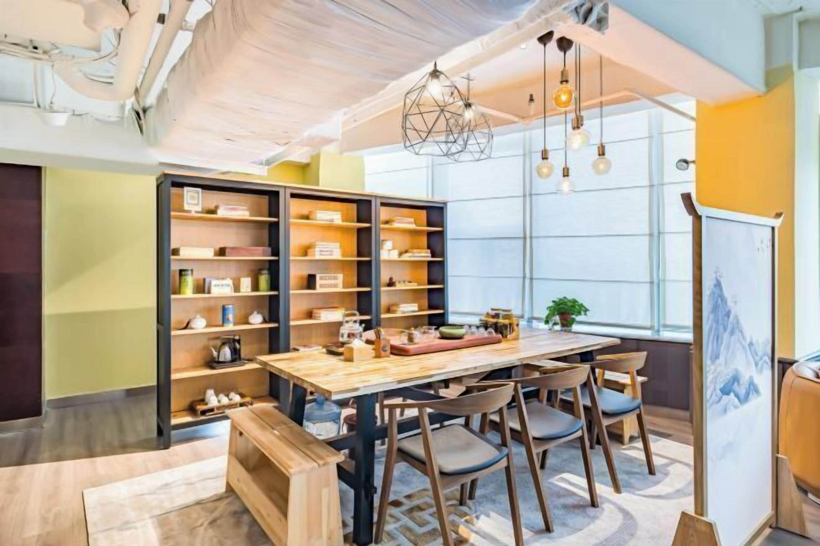 A dining area with a wooden table, chairs, and a bookshelf.