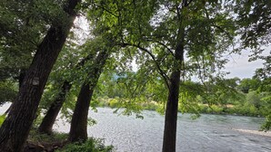 Ein Fluss, umgeben von Bäumen und viel Grün.
