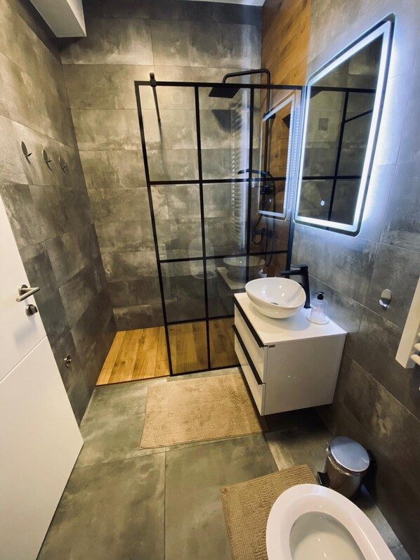 Une salle de bain moderne avec une douche, un lavabo et des toilettes.