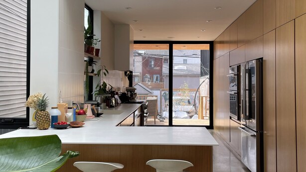 A modern kitchen with a central island, stainless steel appliances, and a view to the outside. - Luxury Family Home Near Beaches & Parks | Sleeps 9 | Chef’s Kitchen & Yard (Toronto)