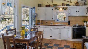 A kitchen with wooden cabinets, a stove, and a dining area with a checkered floor.