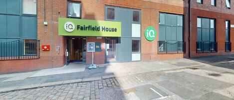 A brick building with a green sign reading "Fairfield House" and an "iQ" logo.