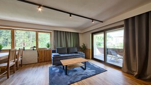 Ein modernes Wohnzimmer mit einer Couch, einem Couchtisch und einem Essbereich mit Holzmöbeln.
