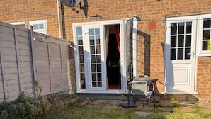 Un bâtiment en briques avec une porte blanche et une antenne parabolique fixée au mur.