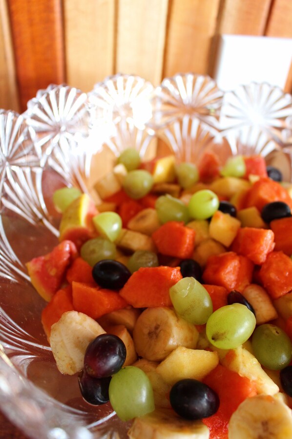 Un cuenco de vidrio transparente lleno de frutas y verduras variadas.