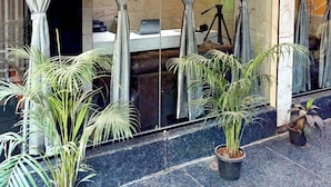 A modern lobby with a marble floor, potted plants, and a reception desk. - GVP Residency (Bengaluru)