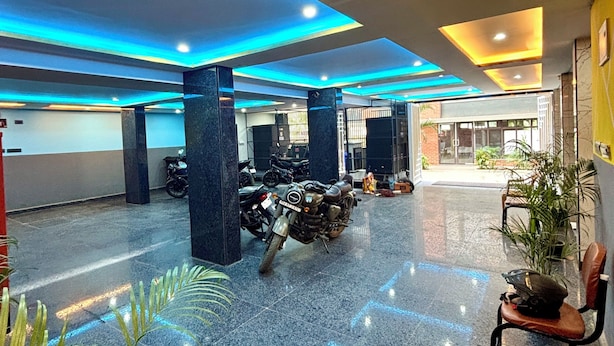 A spacious lobby with a polished floor, seating area, and ceiling lights. - GVP Residency (Bengaluru)