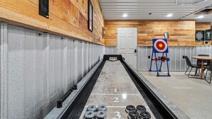 A bowling alley with a wooden wall, a dartboard, and a dartboard with a target.