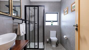 A bathroom with a shower, toilet, and sink.